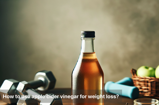 Bottle of apple cider vinegar with dumbbells and apples in the background