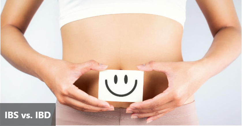 A close-up of a person's abdomen with hands forming a heart shape around a small card featuring a smiley face